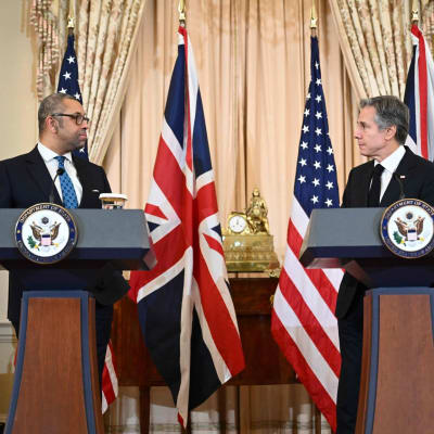 Britannian ja Yhdysvaltojen ulkoministerit James Cleverly ja Antony Blinken seisovat lehdistötilaisuudessa Washingtonissa, taustalla molempien maiden lippuja.