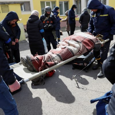 Ukrainan terveydenhuoltohenkilöstö auttaa loukkaantunutta pakolaista, joka on evakuoitu Irpinistä Kiovaan 27.3. 2022. 