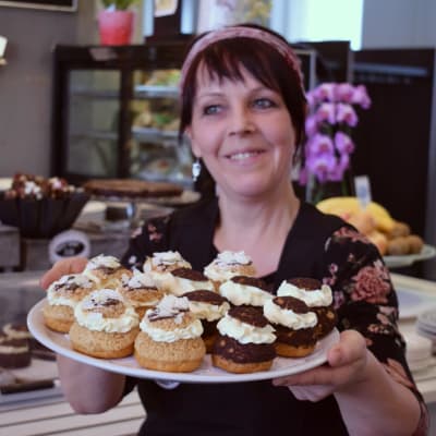 Riitta Wuorio-Bäck håller fram en bricka med fastlagsbullar.