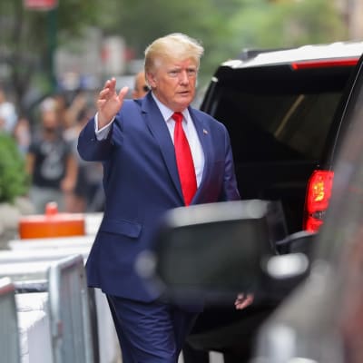 Entinen presidentti Donald Trump vilkuttaa kädellään lähtiessään Trump Towerista New Yorkissa.