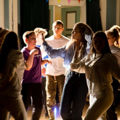 En grupp tonåringar dansar på en fest. 