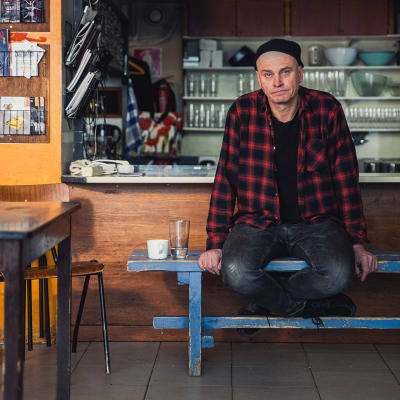 Vakiopaineen baarimikko Matti Perälä istuu jakkaralla ja katsoo kameraan.