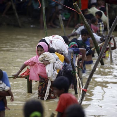 Rohingyapakolaisia ylittämässä jokea.