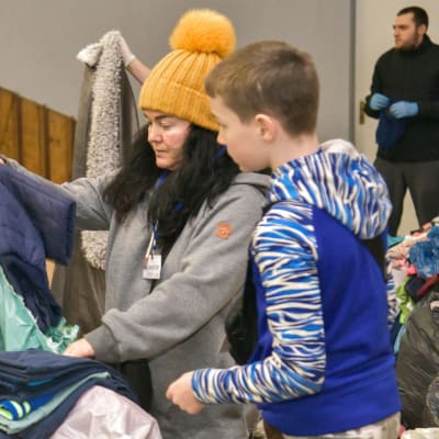 Vapaaehtoiset lajittelevat vaatteita sotilaita ja pakolaisia varten avustuskeskuksessa Ukrainan Lvivissä 2.3.2022.