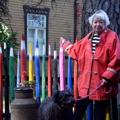 Maikki Harjanne och hennes hund vid staket av stora pennor.