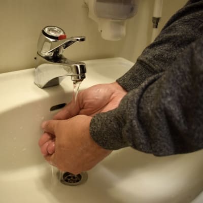 En person tvättar händerna.