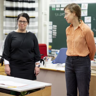 Li Andersson keskustelee opettajan ja oppilaan kanssa Varissuon koulun luokassa.