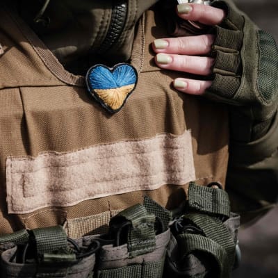 Ukrainalaisella sotilaalla roikkuu kaulassa sydänriipus, jossa on Ukrainan lipun värit.