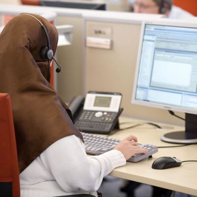 Muslimi nainen työskentelee puhelinkeskuksessa.