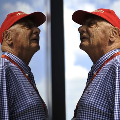 Niki Lauda katselee yläviistoon, peilikuva hänestä heijastuu kuvassa vasemmalla.