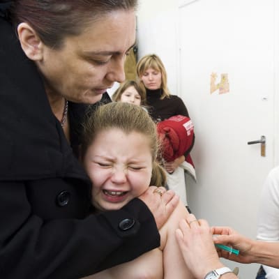 Tyttöä rokotetaan sikainfluenssaa vastaan.