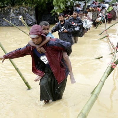 Rohingyapakolaisia ylittämässä jokea.