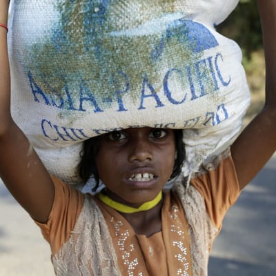 Rohingya-tyttö kantaa säkkiä.
