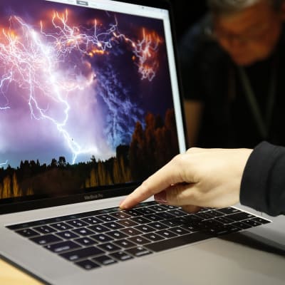 Naisen käsi Apple kannettavan tietokoneen näppäimistöllä.