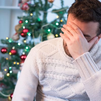 Ahdistunut, stressaantunut mies jouluna alla.