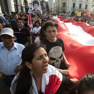 Entisen presidentin armahtamista vastustavia mielenosoittajia Perun pääkaupungissa Limassa. Kulkueessa kannettiin Perun lippuja ja kuolleiden omaisten kuvia.