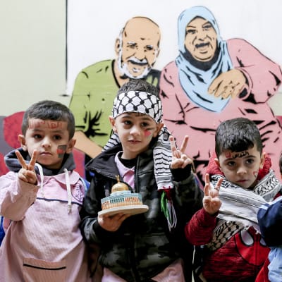Palestiinalaislapset poseeraavat UNRWA:n koulussa.