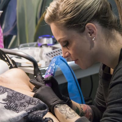 Alexia Cassar tatuoi asiakastaan.