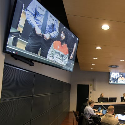 Toimittajat seuraavat Turun elokuisen puukkoiskun käsittelyä videonäytöiltä Turun oikeustalolla 17. huhtikuuta.