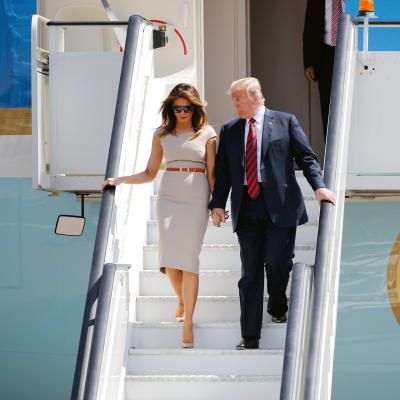 Yhdysvaltain presidentti Donald Trump ja Melania Trump laskeutuvat lentokoneesta käsi kädessä Stanstedin lentokentällä Lontoossa.