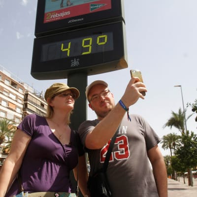 Turistit ottivat selfien lämpömittarin edessä Cordobassa, Espanjassa 1. elokuuta.