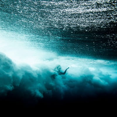 Vedenalainen kuva surffarista Tahitilla.