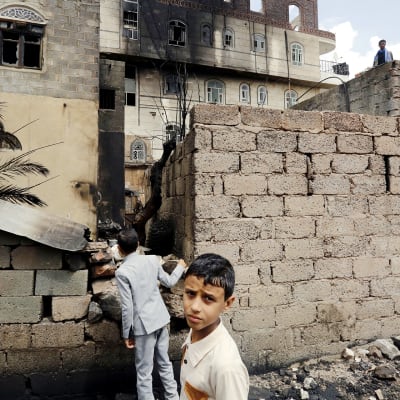 Jemeniläiset pikkupojat tutkivat palanutta taloa Sanaassa
