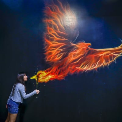 Nainen syöksee tulta taidenäyttelyssä