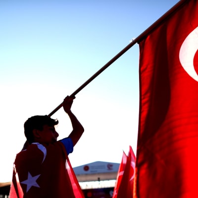 Mies heiluttaa Turkin lippua.