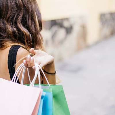 En kvinna med shoppingkassar i handen.
