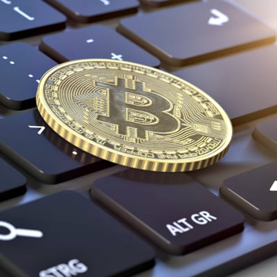 Bitcoin -kolikko näppäimistön päällä.