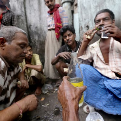 Itsevalmistettua maalaisviinaa juodaan kadulla Kalkutassa.