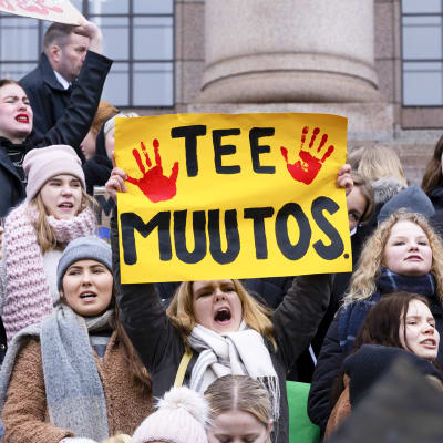 Nuoria mielenosoittajia eduskuntatalon edustalla kansainvälisen nuorten ilmastolakon marssilla Helsingissä perjantaina 15. maaliskuuta.