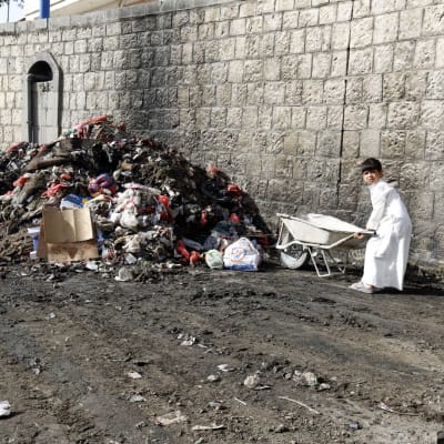 Jemeniläispoika työnsi roskia kottikärryssä Sanaassa viime viikolla. Roskia kasattiin ja desinfioitiin taistelussa koleraepidemiaa vastaan.