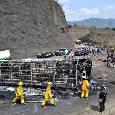 Pelastushenkilökunta jatkaa onnettomuuspaikan raivausta Meksikon Coatzacoalcosissa. Paikalla on myös poliisiautoja ja uteliaita siviilihenkilöitä.
