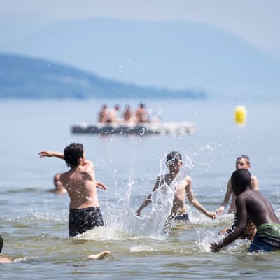 Lapsia heittelemässä palloa Lac de Neuchatel -järvellä Yverdon-les-Bainsissa Sveitsissä-