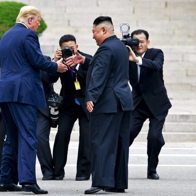 Donald Trump ja Kim Jong-un juuri kättelemässä.