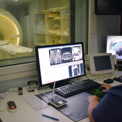 Röntgenhoitaja Viivi Hyvönen tarkkailee magneettikuvauksen kulkua monitorien avulla.