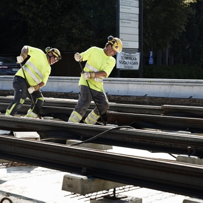 Miehet rakentavat Tampereella raitiotietä.