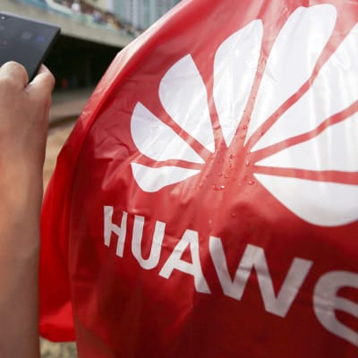 Huawei logo ja miehen kädessä Huawein puhelin.