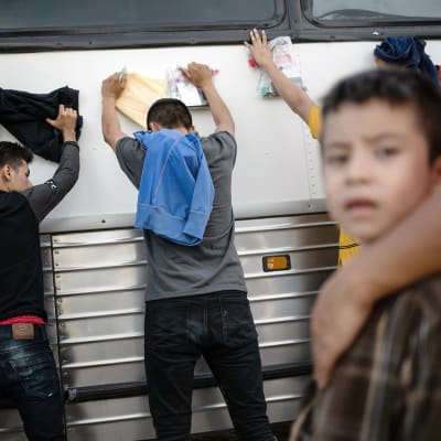 Maahanmuuttajat odottavat rajavartioita Meksikon ja Yhdysvaltain välisellä raja-alueella.