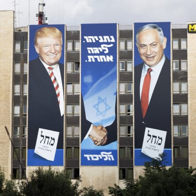 Bibi ja Trump kättelevät suuressa kerrostalon päätyyn pystytetyssä jusiteessa. 