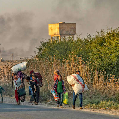 Siviilit pakenevat Turkin pommituksia Syyrian koillisosassa 9. lokakuuta.