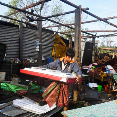 Mies raivaa Bulbul-myrskyn tuhoamaa taloa 10. marraskuuta Bakkhalissa.