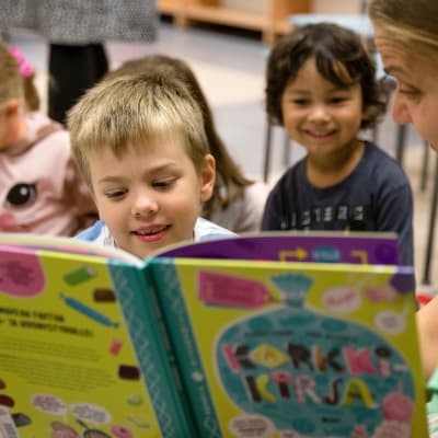 Lapsia lukemassa kirjoja kirjastossa.
