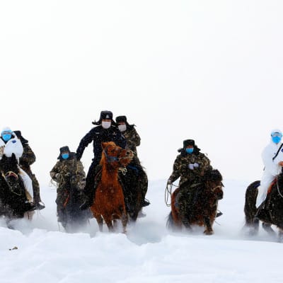 Rajaviranomaiset matkaavat lumen läpi tutkiakseen vuoristoista raja-aluetta ja toimittaakseen tietoja koronaviruksesta. Kiinan Xtajiangin maakunnan Altayn syrjäisen alueen asukkaille.