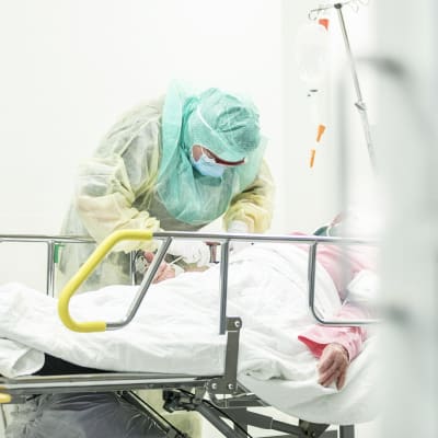 Hoitaja ottaa näytettä koronaepäillyltä koronapotilaiden testaamiseen ja hoitoon tarkoitetulla osastolla Turun yliopistollisessa keskussairaalassa