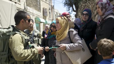 Lärare protesterar mot att israeliska soldater vägrar släppa dem förbi vägspärren