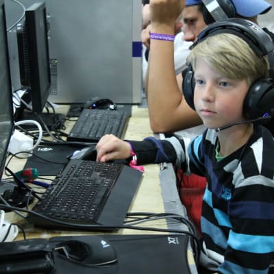 Ung pojke sitter vid en dator.
