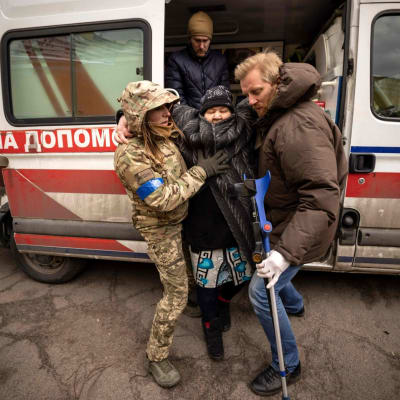 Vanhaa naista autetaan ulos ambulanssista sunnuntaina Stoyankassa Kiovan lähellä.